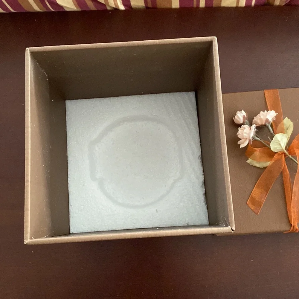 Pretty storage/gift box. Cardboard. Bronzish color with orange ribbon and flower